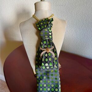 Elegant Black and Green Polka Dot Tie with Gold Brooch and Pocket Square